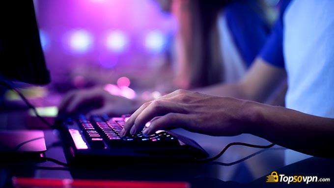 VPN para gaming: Un muchacho jugando con la computadora, utilizando un teclado.